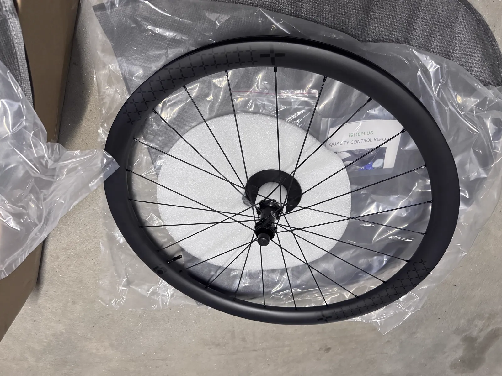 Rear wheel in its packaging with the printed quality control report behind it