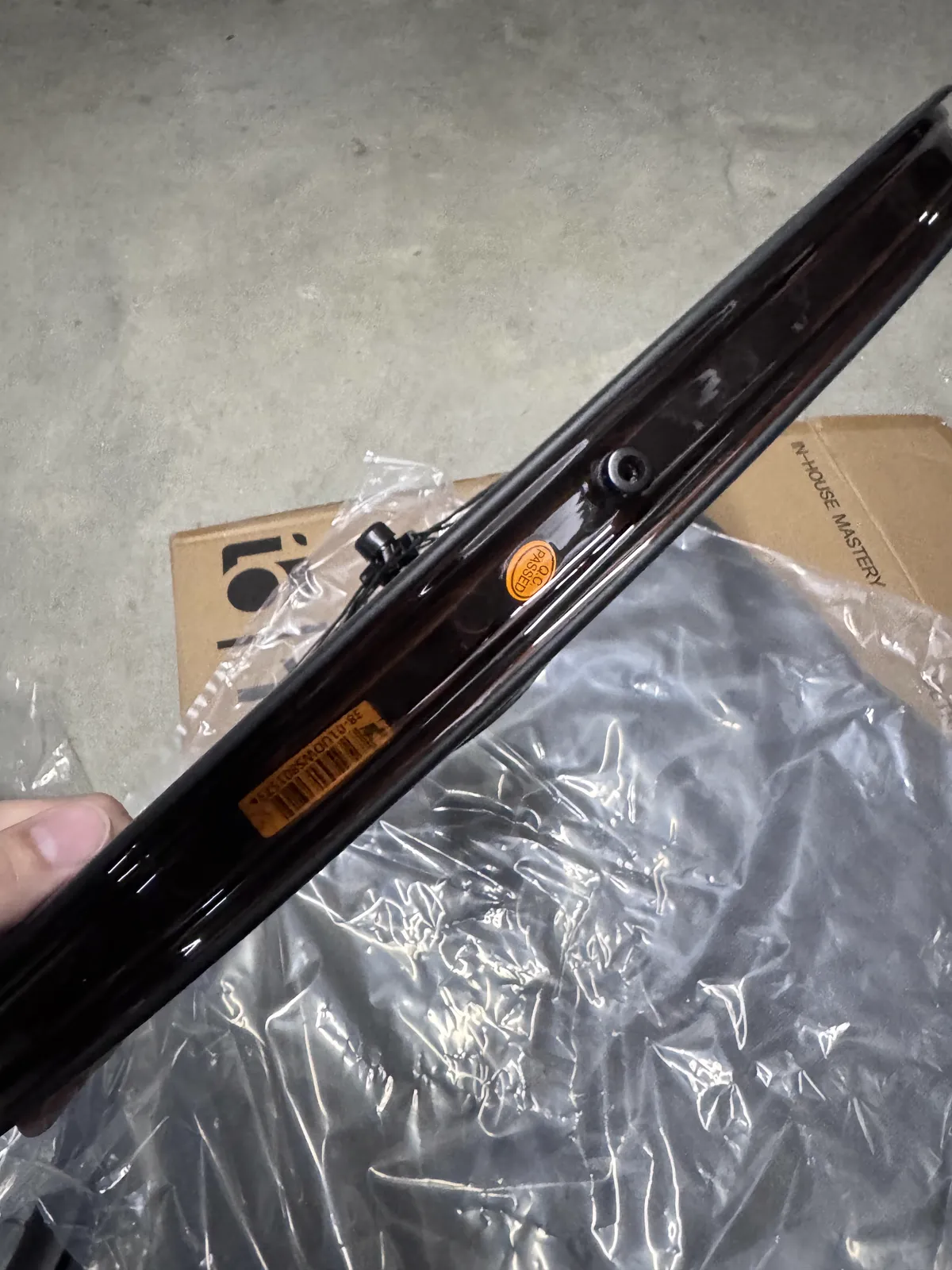 Rim bed with tubeless tape, valve nut and an orange inspection sticker